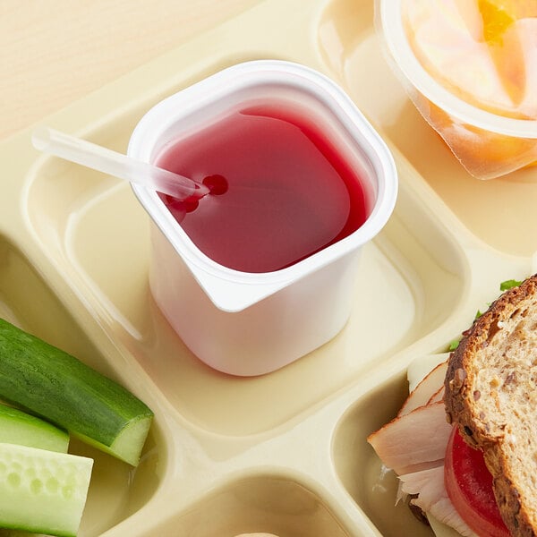 A tray with a sandwich and a cup of Ocean Spray Cranberry Juice Cocktail.