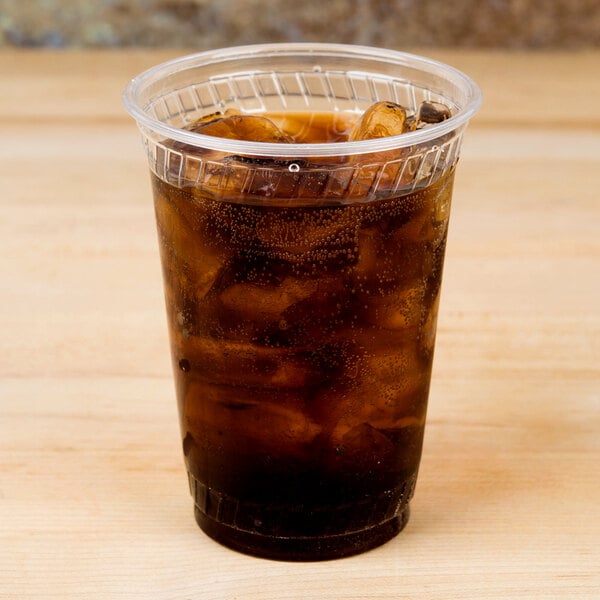 A Fabri-Kal Greenware plastic cup filled with a brown drink and ice.
