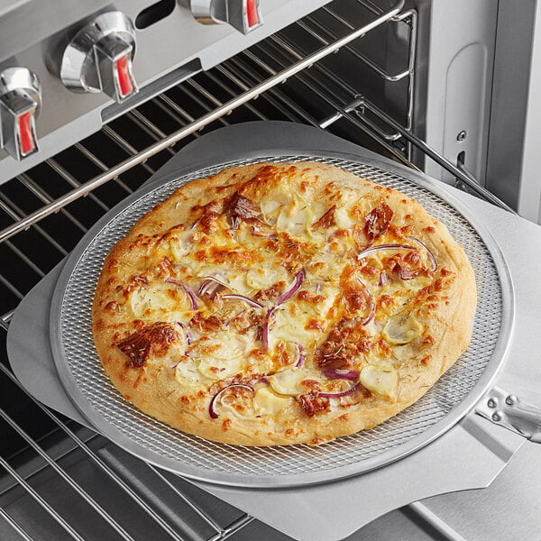 A pizza on a Choice aluminum pizza screen in an oven.