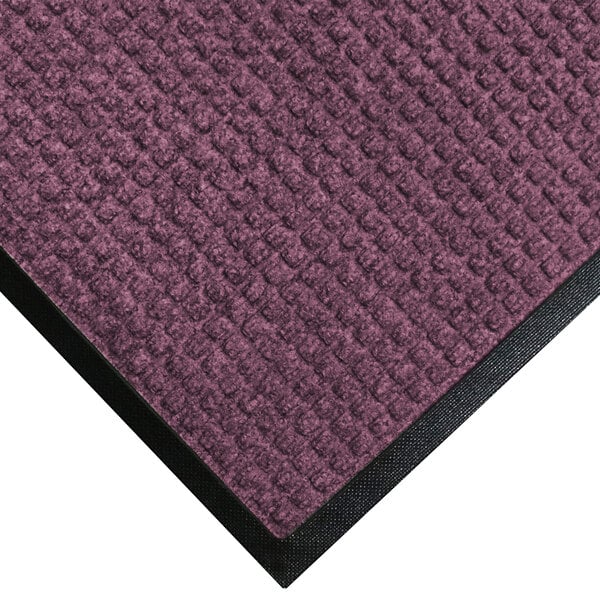 A purple M+A Matting WaterHog mat with a black rubber border.