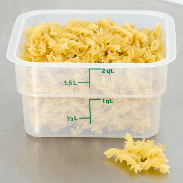 A translucent Cambro square polypropylene food storage container with pasta inside and measurements on the side.