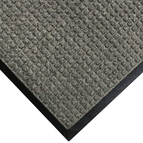 A close-up of a grey carpet mat with black rubber border.