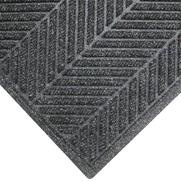 A close-up of a grey M+A Matting WaterHog mat with a chevron pattern.