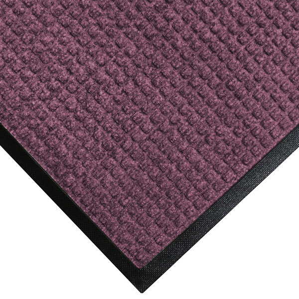 A purple WaterHog Classic mat with black rubber border.