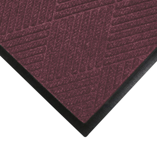 A maroon WaterHog mat with a black rubber border.