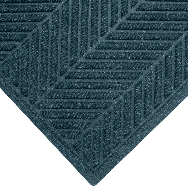 A close-up of a blue WaterHog carpet mat with a chevron patterned border.