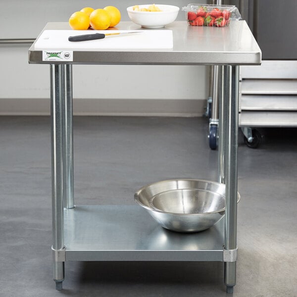 A Regency stainless steel work table with a bowl of oranges on it.