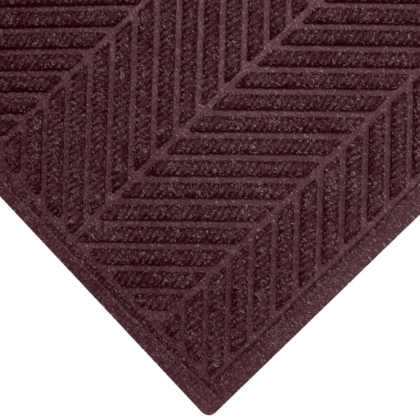 A maroon WaterHog mat with a chevron patterned border.
