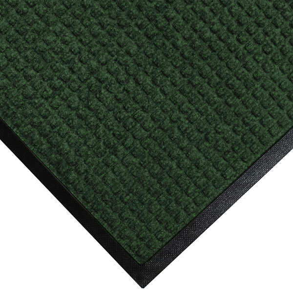 A green WaterHog doormat with black rubber trim.