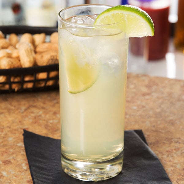 A Libbey tall highball glass of limeade with a lime wedge on top.