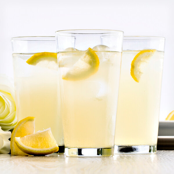 A group of Fortessa Basics Barca highball glasses filled with lemonade and garnished with lemon slices.