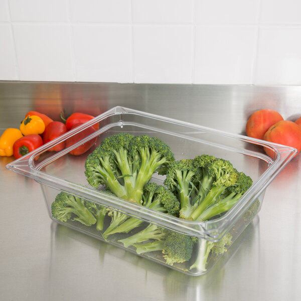 A clear plastic Carlisle food pan with broccoli in it.