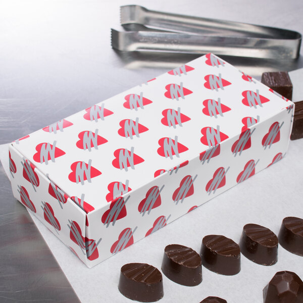 A 1/2 lb. heart candy box on a counter filled with chocolates.