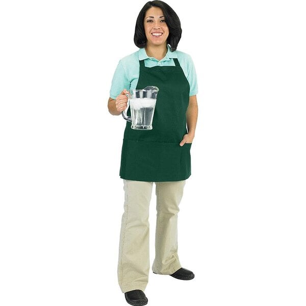 A woman in a Chef Revival hunter green apron holding a pitcher of water.