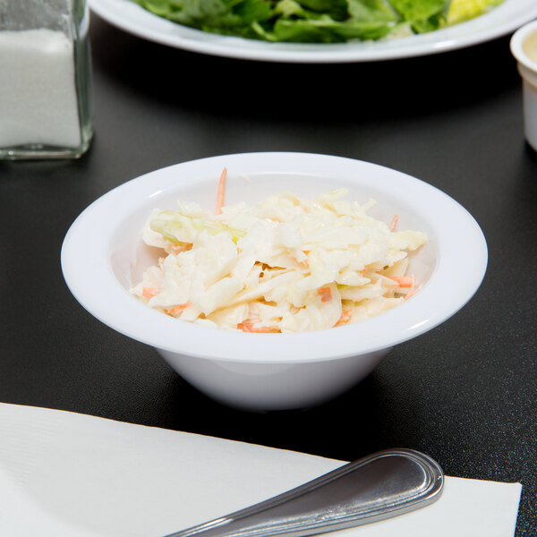 A white melamine bowl filled with coleslaw.