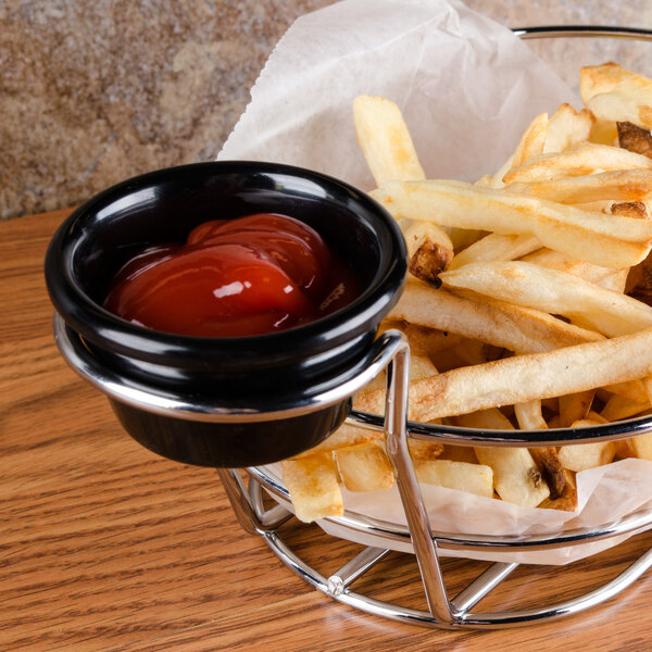 A bowl of french fries with ketchup served in a Thunder Group black melamine ramekin.