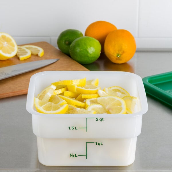 A Cambro white square food storage container with sliced lemons inside.