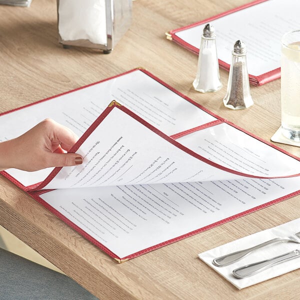 A hand opening a Choice Burgundy Menu Cover on a table in an Italian restaurant.