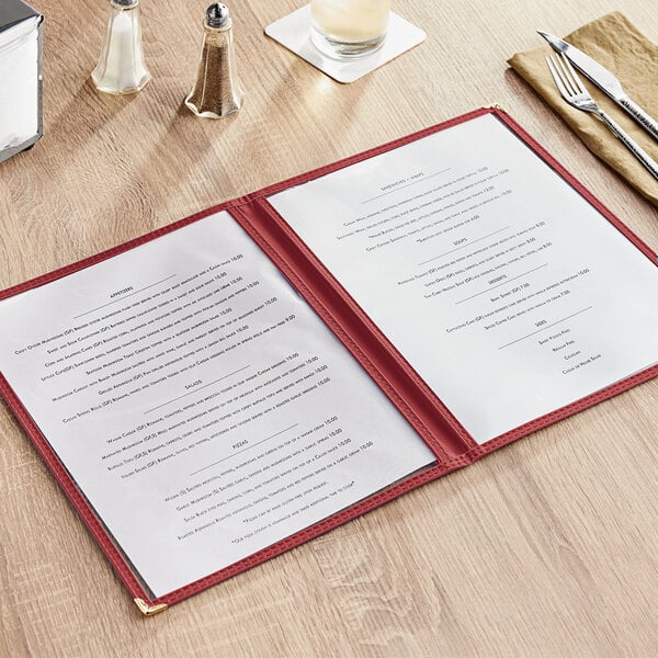 A burgundy menu cover with white trim on a wooden table.