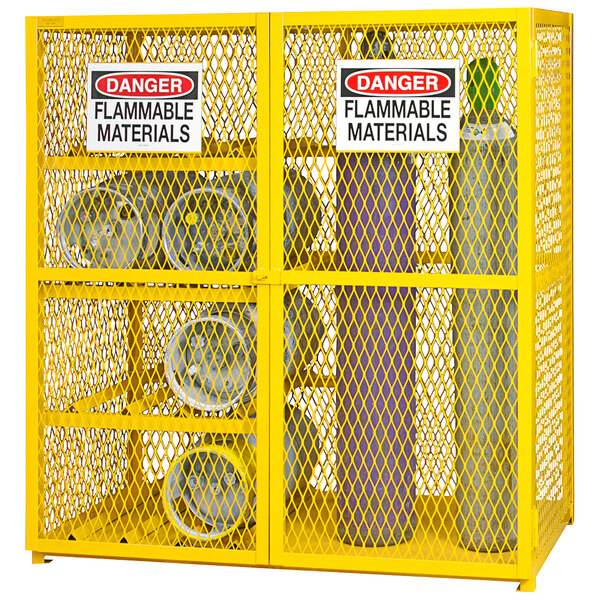 A yellow metal cabinet with a yellow mesh and several cylinders inside.