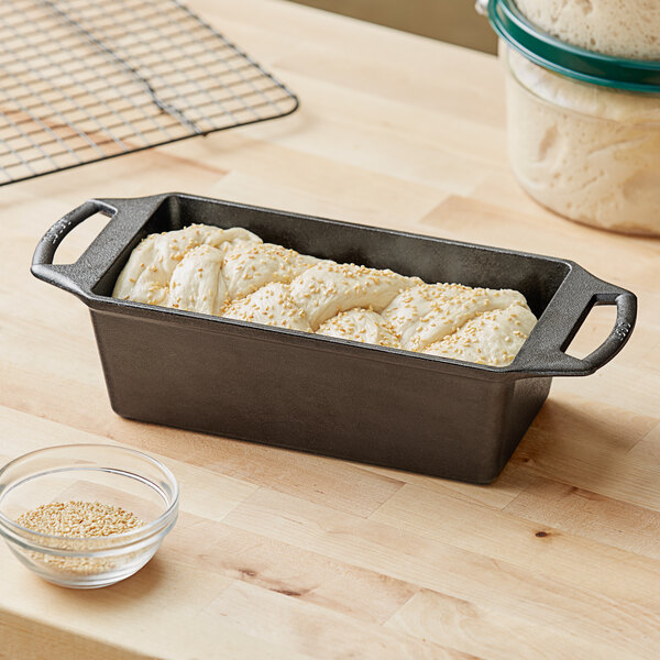 A Lodge pre-seasoned cast iron loaf pan with a loaf of bread baking in it.