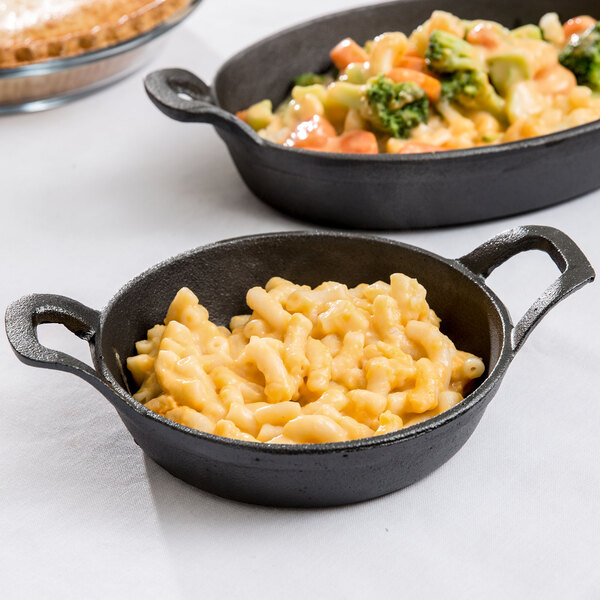Two American Metalcraft pre-seasoned cast iron casserole dishes filled with food on a table.