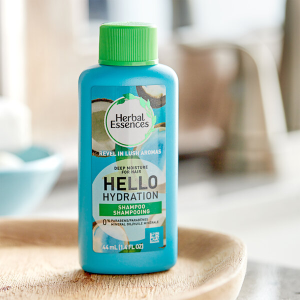 A blue bottle of Herbal Essences Hello Hydration shampoo with a label on a wooden table.