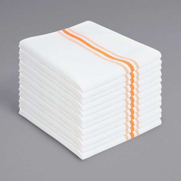 A stack of white cloth napkins with orange stripes.