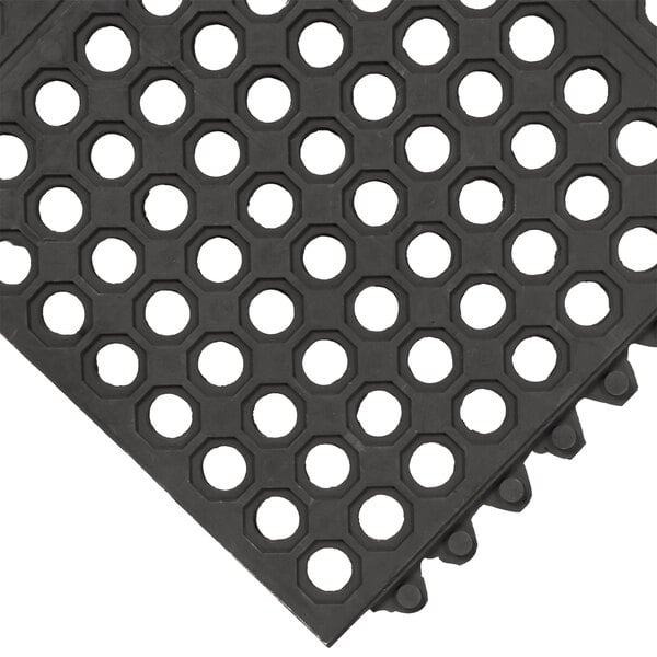 A black rubber Cactus Mat anti-fatigue floor mat with holes on the top.