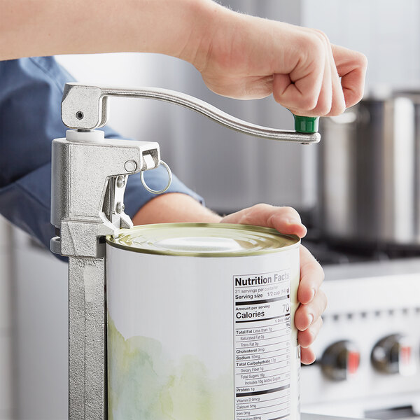 A person using a Garde XL Heavy-Duty NSF manual can opener to open a can of food on a counter.