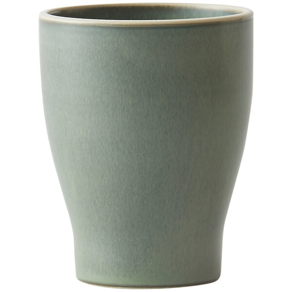 A close-up of a green Oneida Moira stoneware tumbler with a small handle.