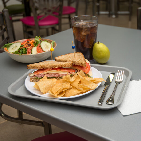 A Carlisle fast food tray with sandwiches, salad, and a drink.