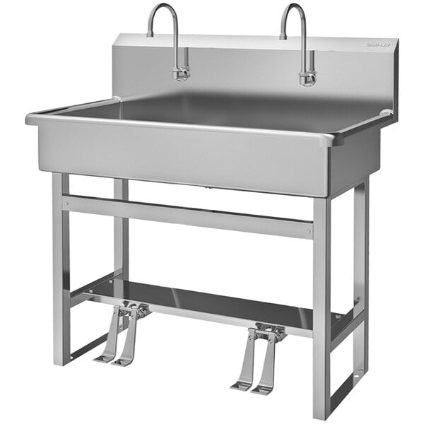 A Sani-Lav stainless steel utility sink with 2 foot-operated faucets.