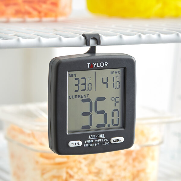 A Taylor digital refrigerator/freezer thermometer on a shelf.