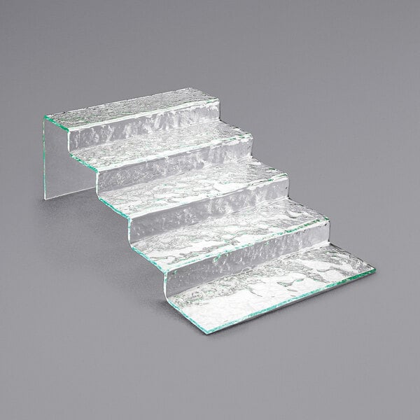 A Cal-Mil Glacier faux glass stair-step riser with a silver surface.