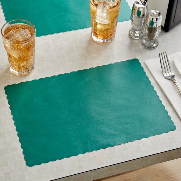 A teal Choice paper placemat with a scalloped edge on a table with glasses of ice tea.