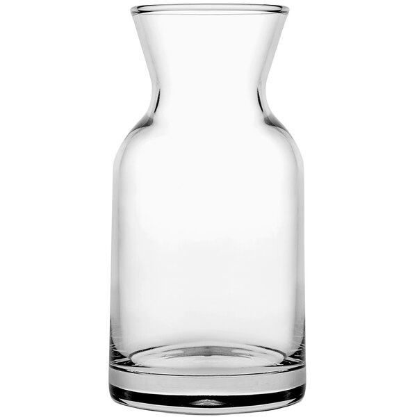 A Pasabahce clear glass carafe with a small amount of liquid in it.