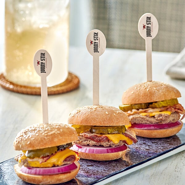 Three customizable oval food picks in burgers on a plate.