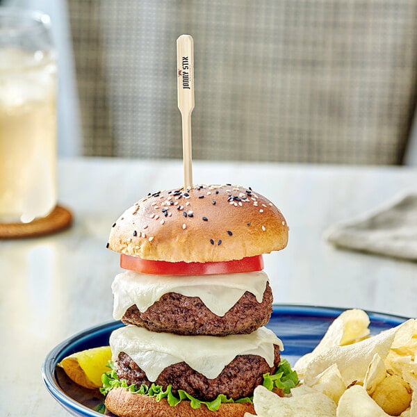 A burger with a customizable paddle pick in it, with cheese and tomato.
