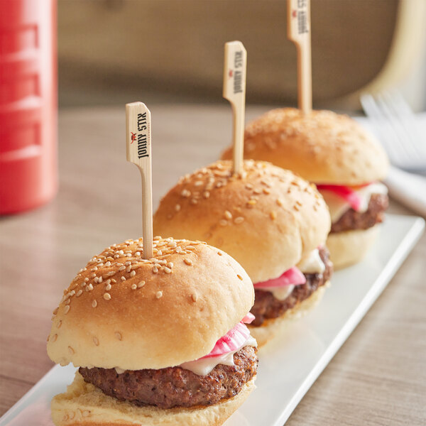 A row of mini burgers on a white plate with Customizable Boat Oar Picks.