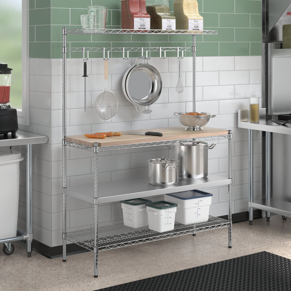 A Regency chrome wire baker's rack with stainless steel and wood shelves in a professional kitchen.
