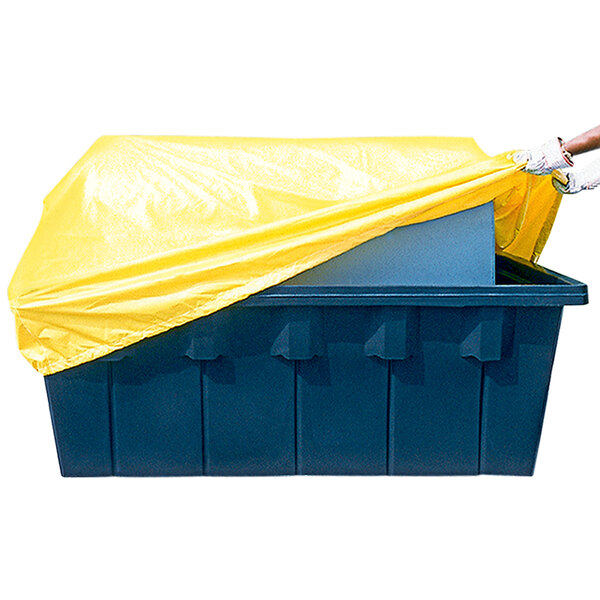 A person putting a yellow PVC cover on a yellow fuel tank.