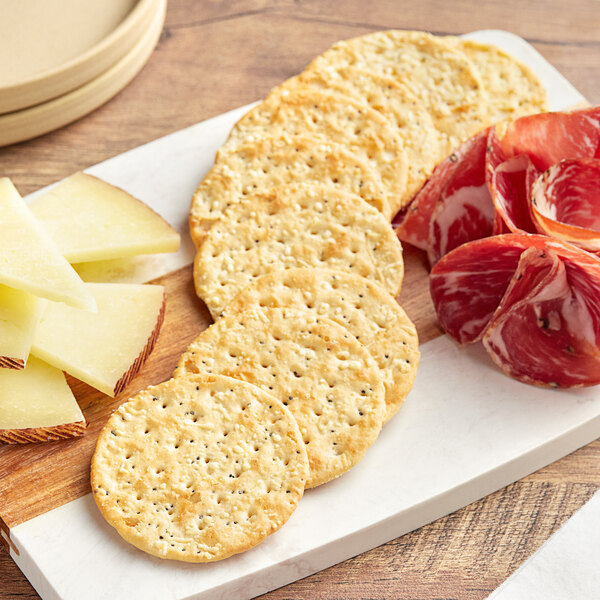 Carr's Cheese Melt Crackers on a cutting board with cheese and crackers.