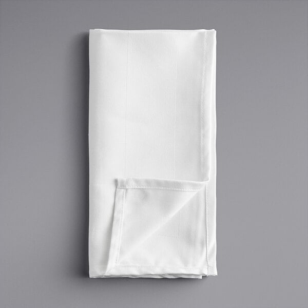A white folded napkin on a gray surface.