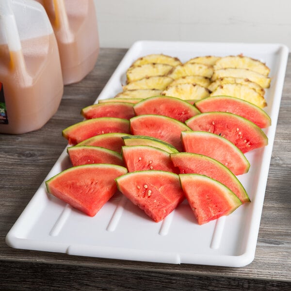 A Winholt polystyrene display tray with watermelon and pineapple slices.