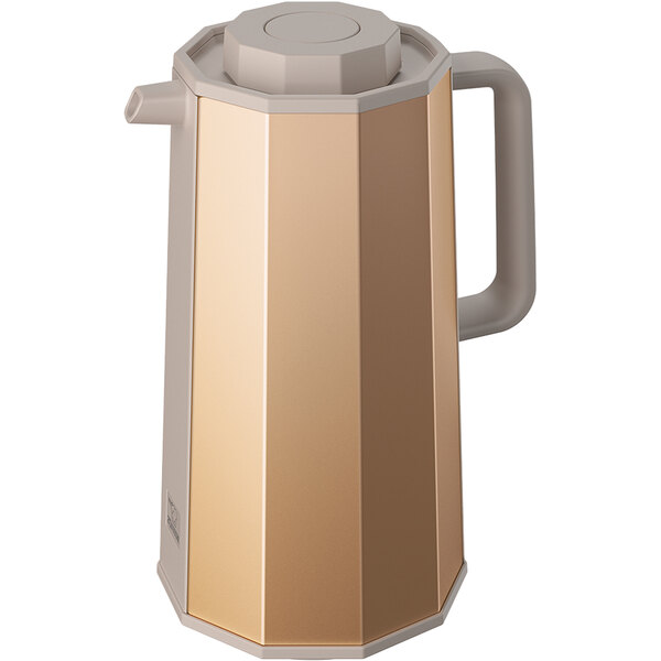 A Zojirushi gold glass-lined coffee carafe with a push-button stopper.