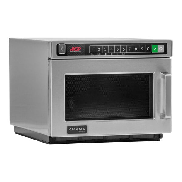 An Amana stainless steel commercial microwave on a counter.