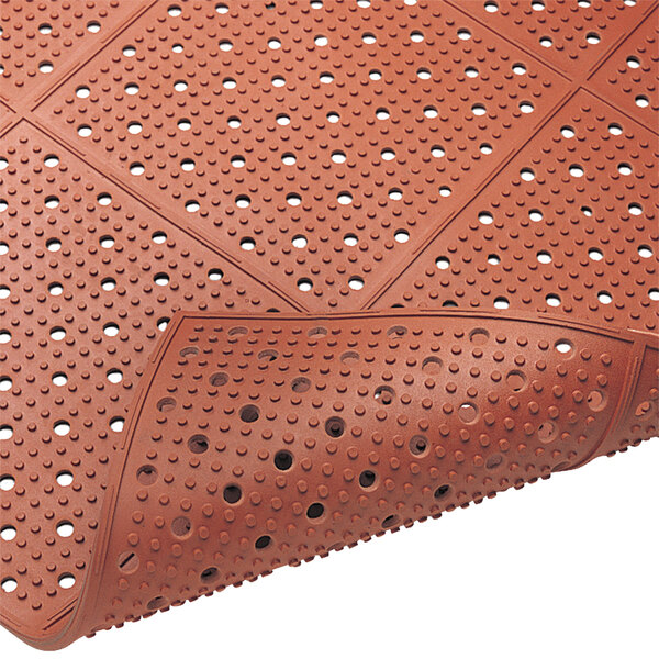 A Cactus Mat red rubber safety runner mat with holes in it.