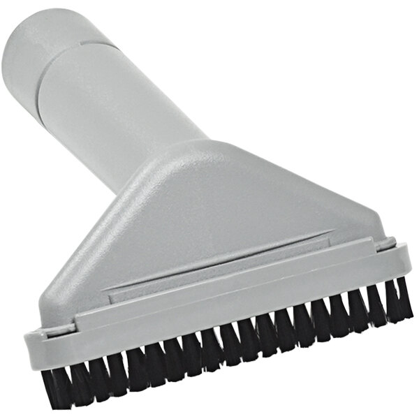 A grey Clarke upholstery tool with black bristles.