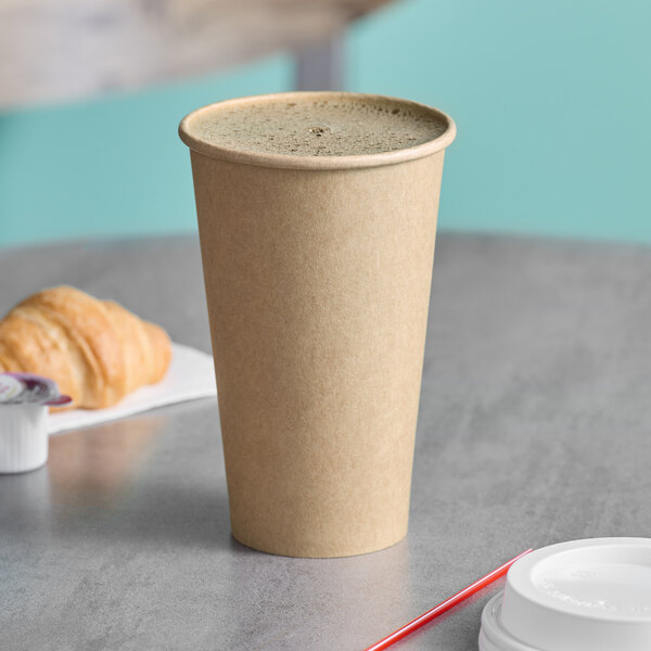 A close-up of a Choice white paper hot cup on a table with a cup of coffee.